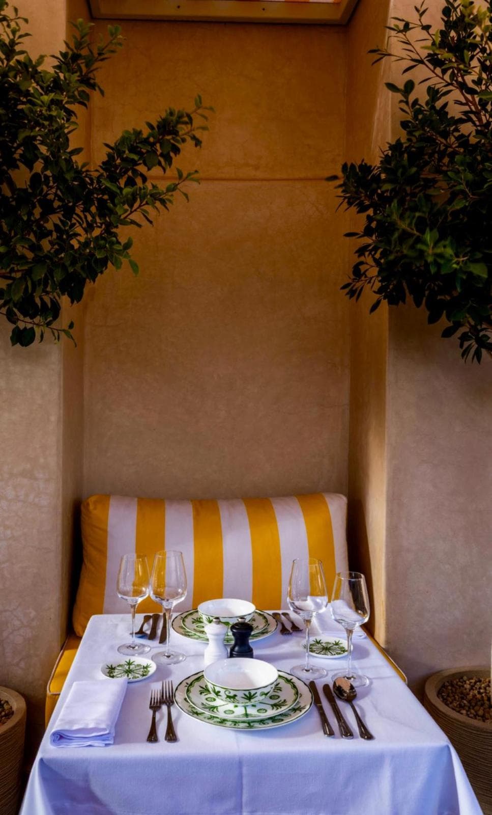 Intimate rooftop dinner setup at Riad Sa'eed under striped awning