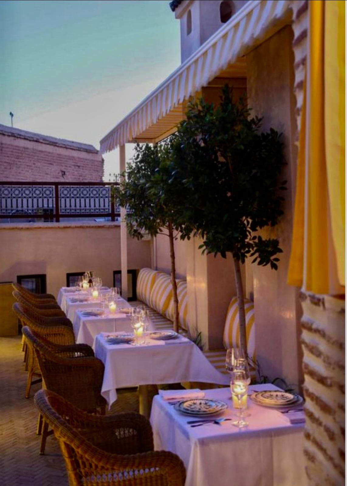 Candlelit dinner tables on the Riad Sa'eed rooftop at twilight
